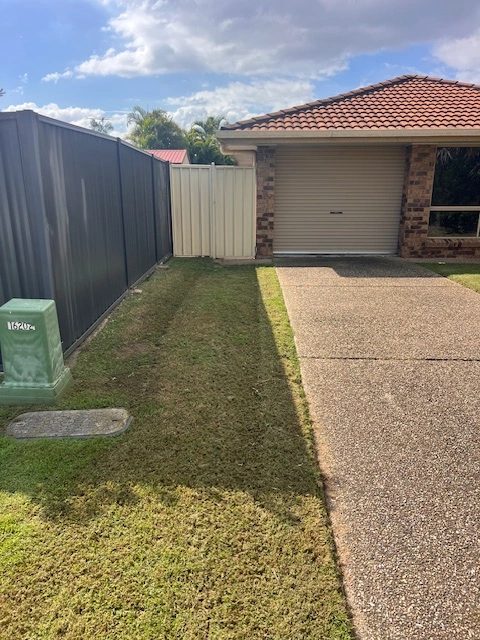 Mown strip of lawn beside a driveway and garage